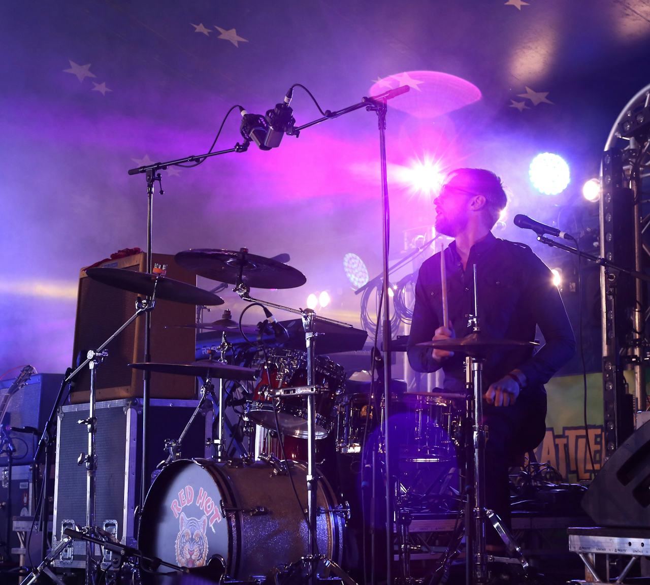 Daniel West with atmospheric stage lighting playing Rock and Roll drums with Red Hot Riot live on stage in England