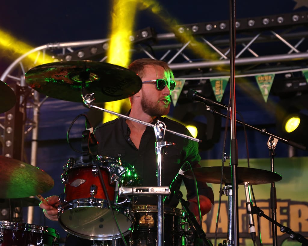 Daniel West playing drums on stage with Red Hot Riot in the UK