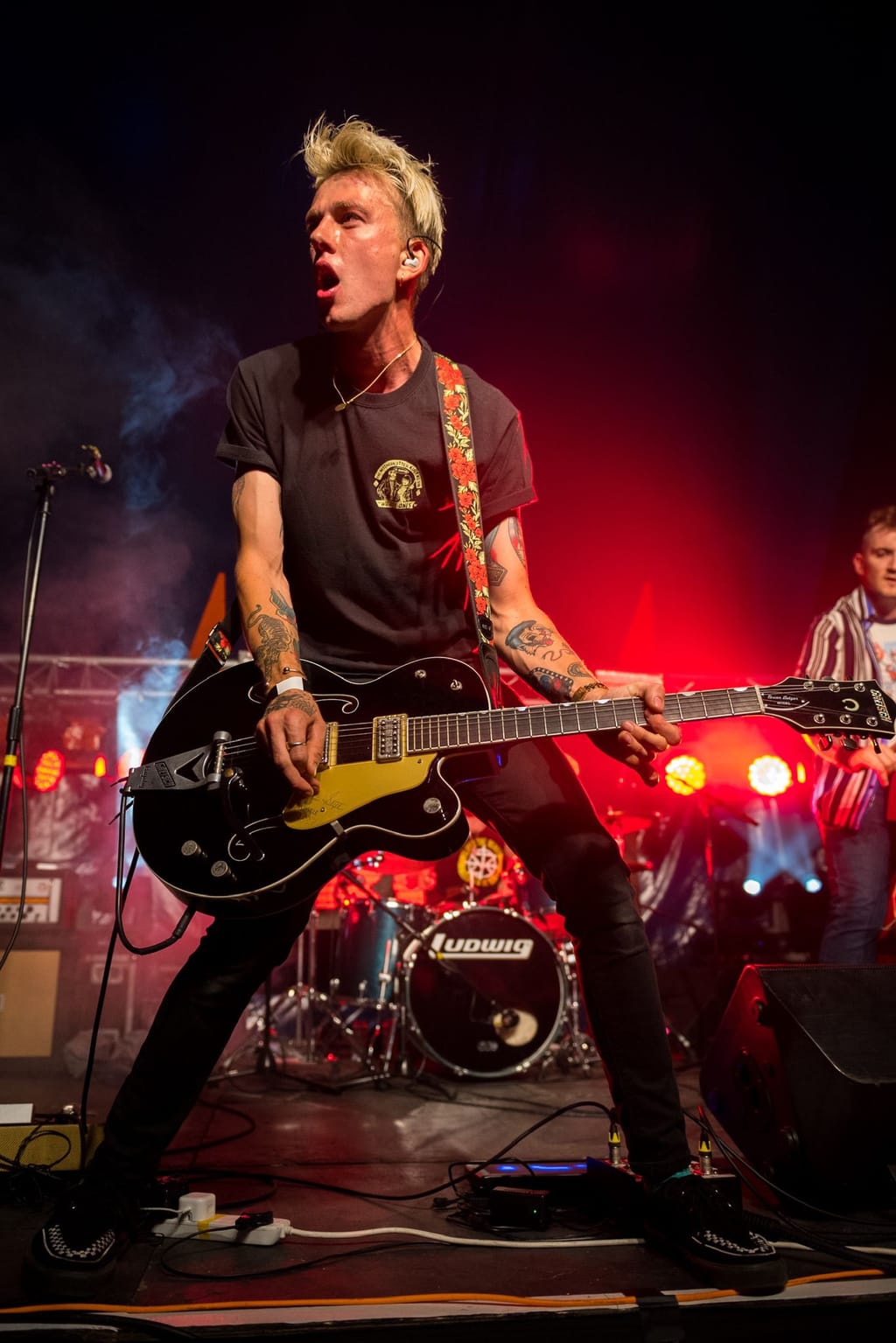 Ricky Delaney playing guitar on stage with Red Hot Riot at a festival